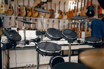 Digital drum set on showcase in music store, closeup view, nobody. Assortment in musical instrument shop, professional equipment for musicians and performers