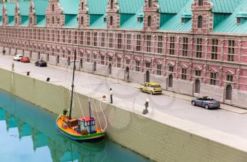 Boat at the pier on city river, miniature scene outdoor, europe. Mini figures with high detaling of objects, realistically diorama