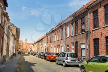 Row of cars on cozy street in old provincial European town, nobody. Traditional architecture. Summer tourism and travels, famous europe landmark, popular places for travelling