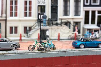 Bicycles at the lamppost on city street, miniature scene outdoor, europe. Mini figures with high detaling of objects, realistically diorama, toy model
