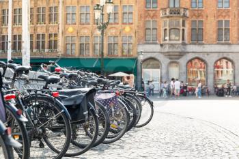 Bycicles on the square, people in street cafe on background, old European tourist town. Summer tourism and travels, famous europe landmark, popular places for travelling