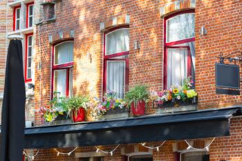 Ancient building facade with flowers, old provincial European town. Summer tourism and travels, famous europe landmark, popular places for vacation tour or holidays