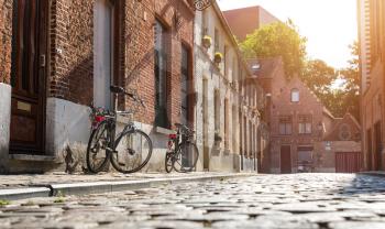 Bicycles at old building facade on cozy street, old provincial European town. Summer tourism and travels, famous europe landmark, popular places