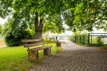 Benches in green park, old European town, nobody. Summer tourism and travels, famous europe landmark, popular places for tourists