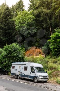 Travelling on mobile home, camping house in the forest, Europe. Road tourism on car, campers vacations, european holidays
