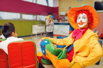 Funny clown animator and group of little boys. Birthday celebrating in playroom, baby holiday in playground. Childhood happiness, childish leisure, entertainment in children's area