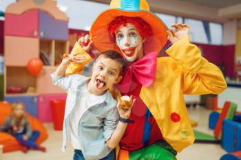 Funny clown, entertainment show with little boys in kindergarten. Birthday celebrating in playroom, baby holiday in playground. Childhood happiness, childish leisure