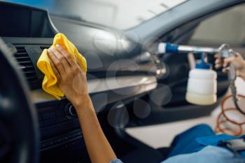 Female washer with sponge cleans automobile interior, car wash service. Woman washes vehicle, carwash station, car-wash business