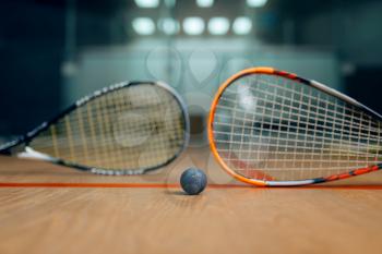 Two squash rackets and ball on court floor, nobody, game concept. Active sport hobby, fitness workout for healthy lifestyle