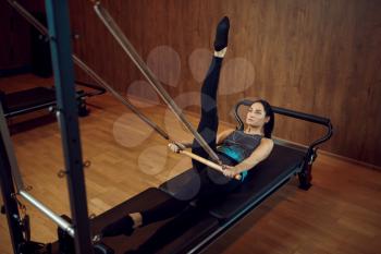 Sporty woman in sportswear doing stretching pilates exercise in gym. Fitness workuot in sport club. Athletic female person, aerobics