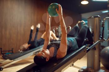 Women with balls on pilates training in gym, flexibility. Fitness workuot in sport club. Athletic female person, aerobics indoor, body stretching
