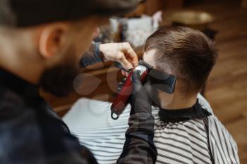 Barber in hat cuts the client 's hair. Professional barbershop is a trendy occupation. Male hairdresser and customer in retro style hair salon
