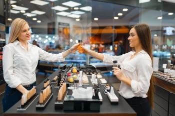 Cosmetician at the counter and woman in cosmetics store. Luxury beauty shop salon, female customer and beautician in fashion store