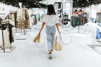 Woman with cardboard bags, clothing store. Female person shopping in fashion boutique, shopaholic, shopper with purchase