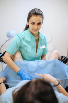 Female gynecologist works with patient in chair. Gynecological examination in clinic, gynecology diagnostic or consultation, exam. Doctor and woman in hospital