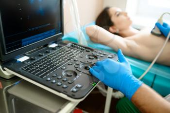 A mammologist makes breast ultrasound scanning in clinic. Breast ultrasonography in hospital, professional diagnostic. Medical specialist and patient, mammography