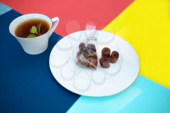 Table setting, tea party decoration, teacup plate with sweets, nobody. Luxury silverware on colorful tablecloth, tableware