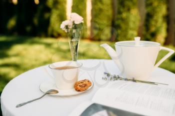 Table setting, romantic tea party with sweets, nobody. Luxury silverware on white tablecloth, tableware outdoors. Wedding celebration on summer meadow
