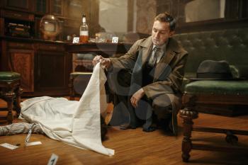 Male detective in coat looking on victim's body at the crime scene, retro style. Criminal investigation, inspector is working on a murder, vintage room interior on background