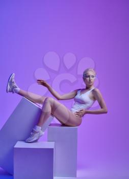 Model in white clothes and futuristic glasses lying on cubes, light background. Female person in virtual reality style, future futurism
