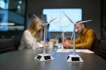 Wind mill models on the table. Team of young managers, idea developing in IT office. Professional teamwork and planning, group brainstorming and corporate work, meeting of colleagues