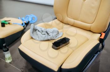 Removed car seats and tools for dry cleaning closeup, detailing. Vehicle washing in garage, thoroughly care of automobile, chemical and vacuum clean service