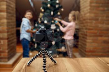 Children bloggers recording xmas blog on camera, vloggers. Kids blogging in home studio, social media for young audience, online internet broadcast
