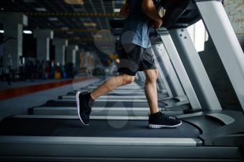 Youngster doing exercise on treadmill in gym, running machine. Boy on training in sport club, health care and healthy lifestyle, child on workout