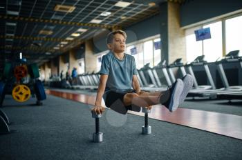 Youngster doing exercise with dumbbells in gym. Boy on fitness training in sport club, healthcare and healthy lifestyle, schoolboy on workout