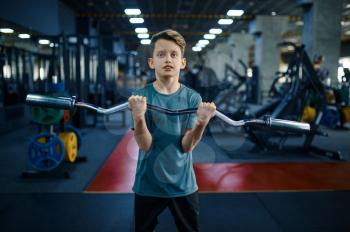 Youngster doing exercise with bar in gym. Boy on fitness training in sport club, healthcare and healthy lifestyle, schoolboy on workout, sportive youth