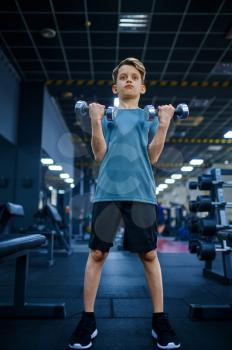 Boy doing exercise with dumbbells in gym, bottom view. Youngster on training in sport club, healthcare and healthy lifestyle, schoolboy on workout, sportive youth