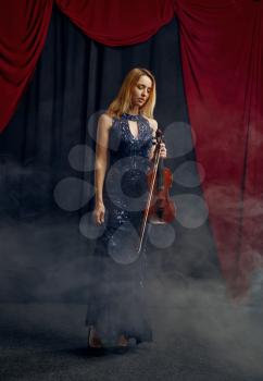 Female violonist holds violin in retro style. Woman with string musical instrument, music art, musician play on viola