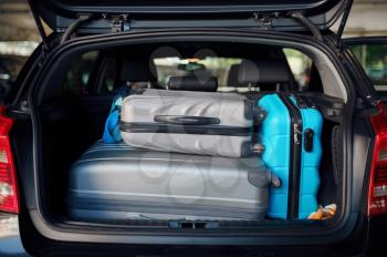 Suitcases in opened car trunk on parking, nobody. Luggage in vehicle, park lot, bags in automobile. Baggage in transport, travelling concept