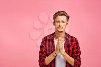 Pathetic man portrait, pink background, emotion. Face expression, male person looking on camera in studio, emotional concept, feelings
