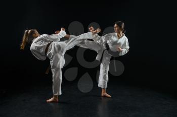 Female and male karate fighters, combat in action, white kimono, dark smoky background. Karateka on workout, martial arts, fighting competition