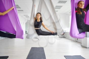 Fly yoga, female group training, hanging on hammocks. Fitness, pilates and dance exercises mix. Women on yoga workout