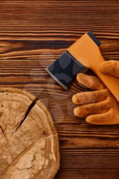 Axe and gloves on wooden background, nobody. Professional instrument, carpenter equipment, woodworker tools