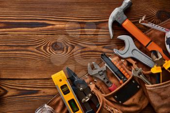 Professional workshop instrument, macro view, wooden background, nobody. Carpenter tools, builder equipment, screwdriver and wrench, piles and metal scissors, hammer and level