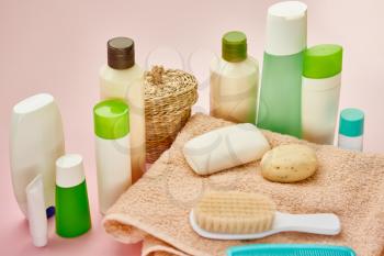 Skin care products on towel, closeup view, pink background, nobody. Morning healthcare procedures concept, hygiene tools, healthy lifestyle