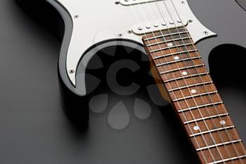 Electric guitar closeup, black background, nobody. String musical instrument, electro sound, electronic music, equipment for stage concert