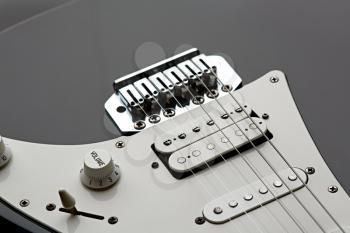 Electric guitar, closeup view on strings, black top on background, nobody. Musical instrument, electro sound, electronic music, equipment for stage concert