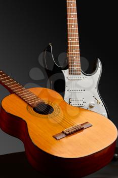 Modern electric and retro acoustic guitars, black background, nobody. String musical instrument, electro and live sound, music, equipment for musician