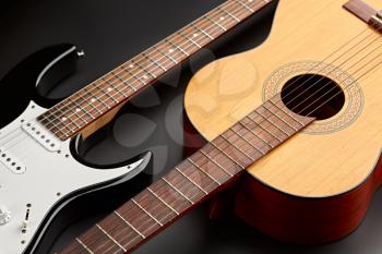 Modern electric and retro acoustic guitars closeup, black background, nobody. String musical instrument, electro and live sound, music, equipment for musician