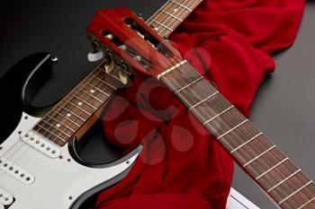 Modern electric and classical acoustic guitars closeup, black background, nobody. String musical instrument, electro and live sound, music, equipment for musician