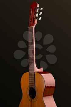 Classical acoustic guitar, black background, nobody. String musical instrument concept, live sound, equipment for musicians, retro style