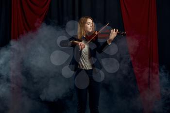 Female violonist with bow and violin, performance on stage. Woman with string musical instrument, music art, musician play on viola