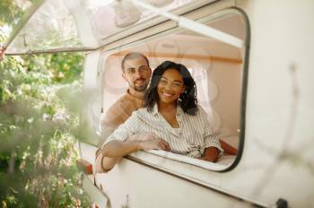 Love couple looks out of rv window, camping in a trailer. Man and woman travels on van, romantic vacations on motorhome, campers leisures in camping-car