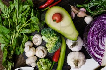 Fresh vegetables and avocado closeup, on wooden background. Organic vegetarian food, grocery assortment, natural products, healthy lifestyle concept