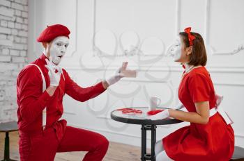 Male and female mime artists, scene with gift. Pantomime theater, parody comedian, positive emotion, humour performance, funny face mimic and grimace