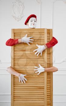 Two mime artists, scene with wooden partition. Pantomime theater, parody comedian, positive emotion, humour performance, funny face mimic and grimace